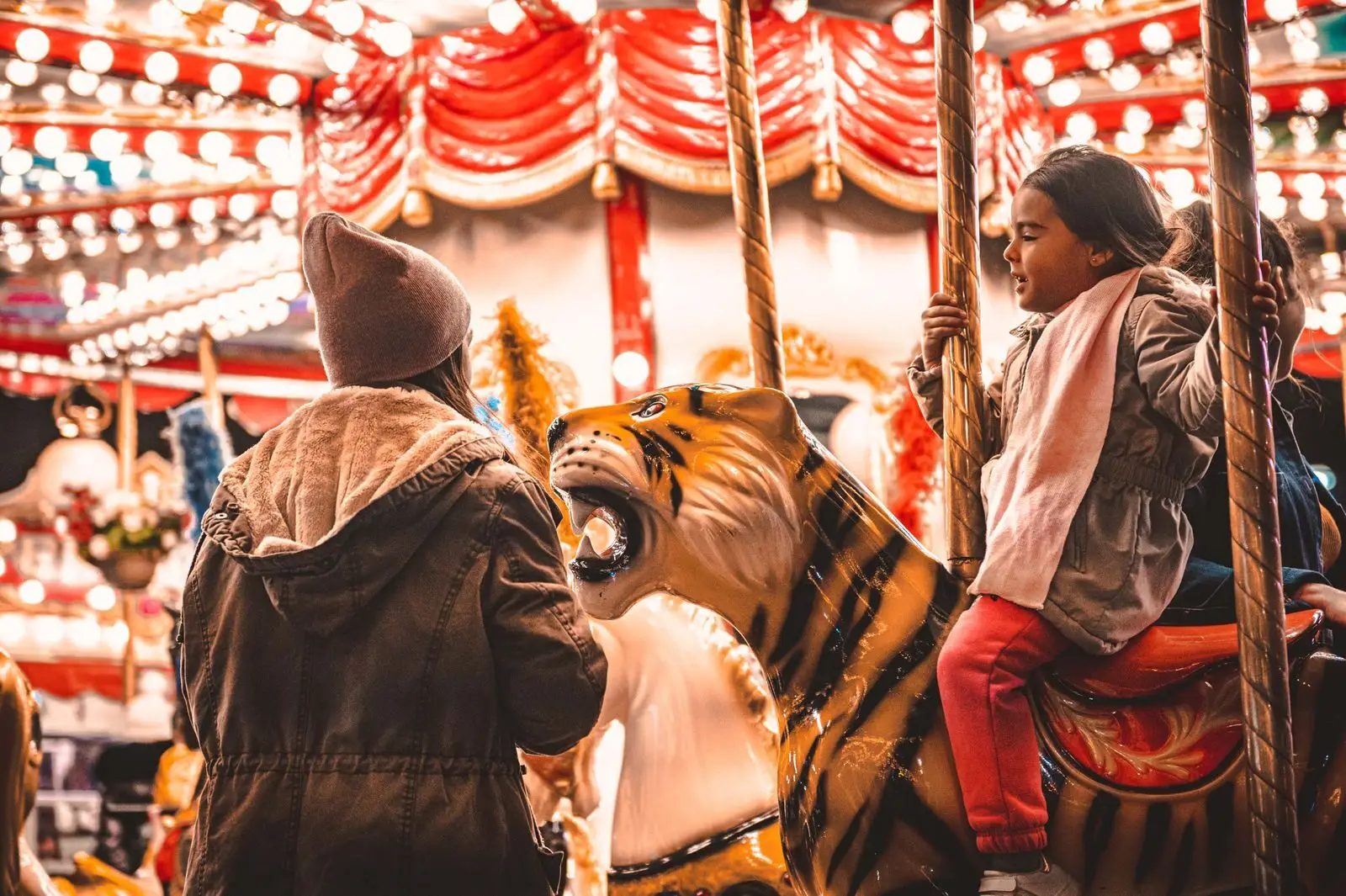 A child enjoys a vibrant carousel ride at night, capturing the essence of fun and excitement.