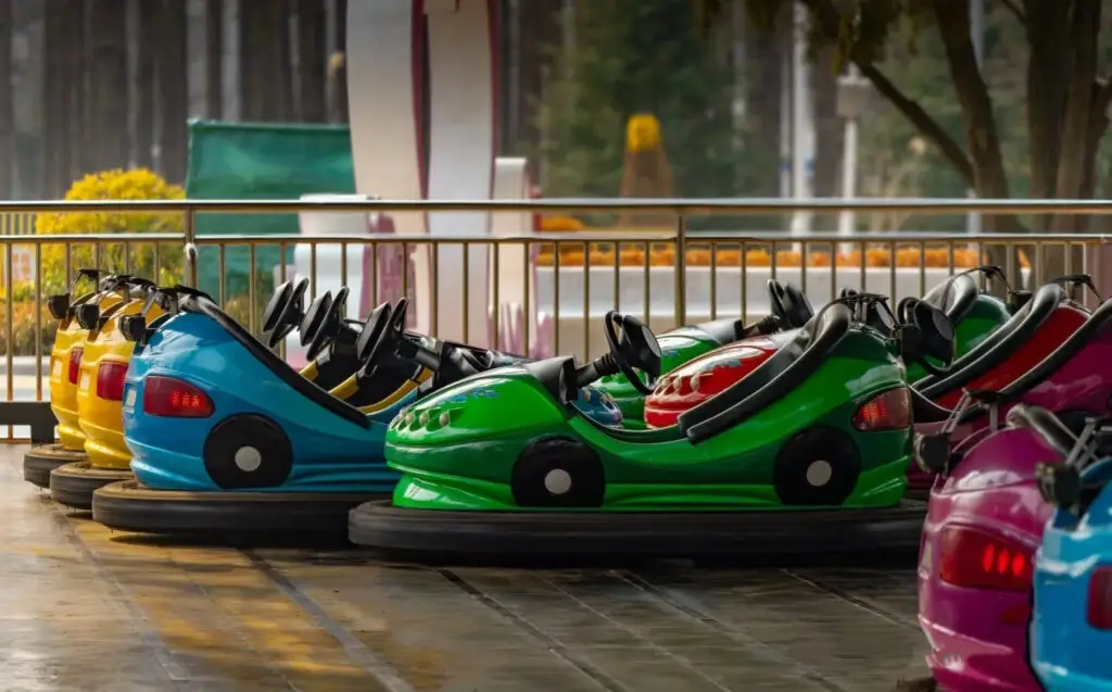 Colorful bumper cars colliding on arena floor with sparks