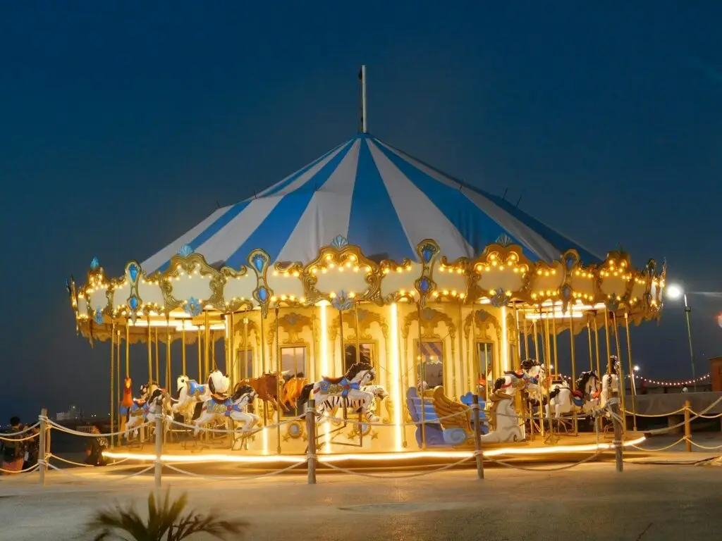 Classic carousel with riders on horseback in park setting