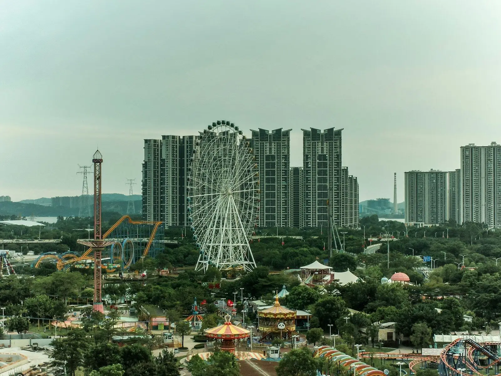 Amusement park with ferris wheel and tall buildings.