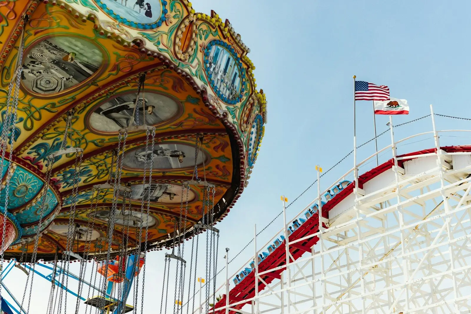 Amusement park swing ride with roller coaster and flags