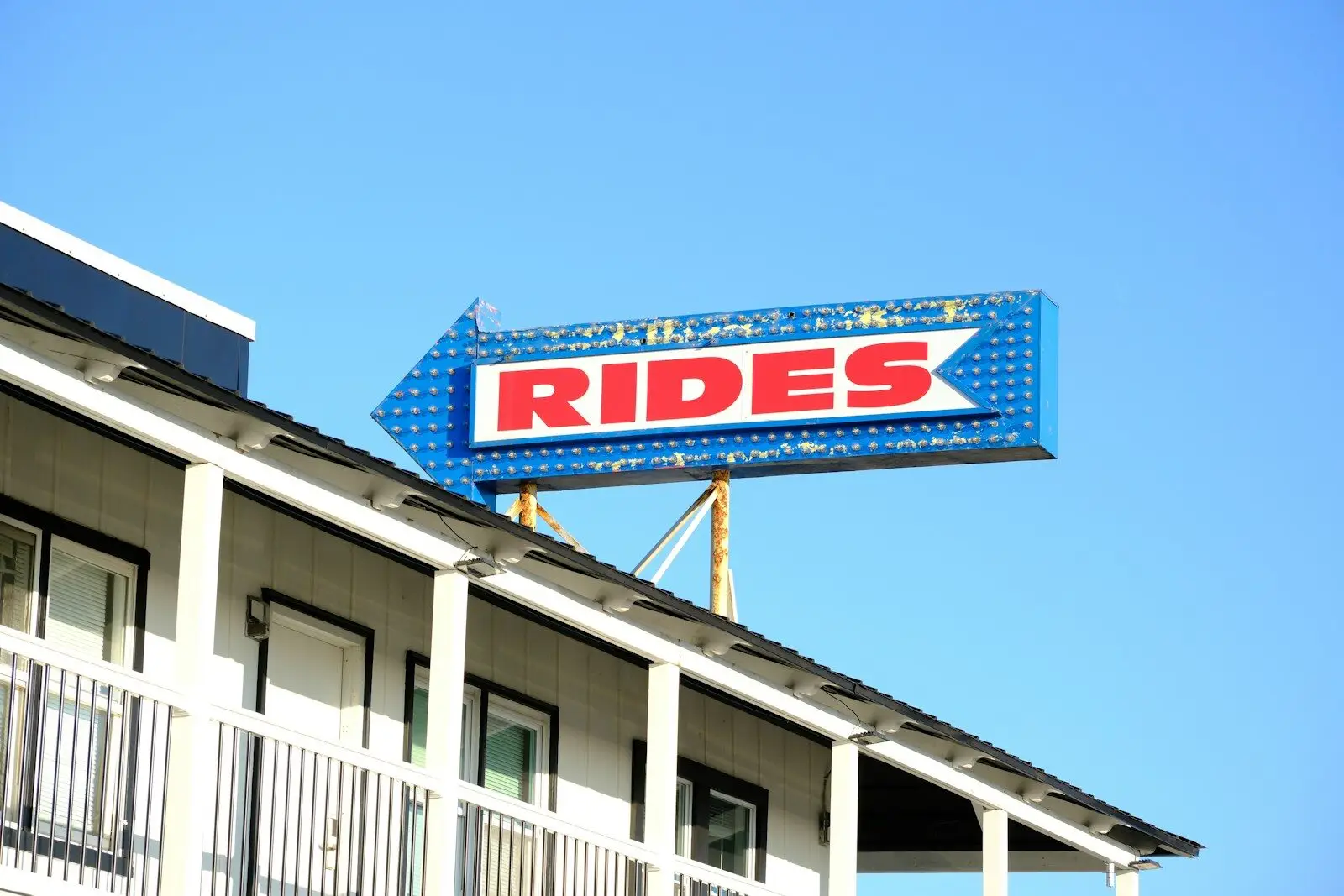 A blue arrow sign pointing left with the word "rides".