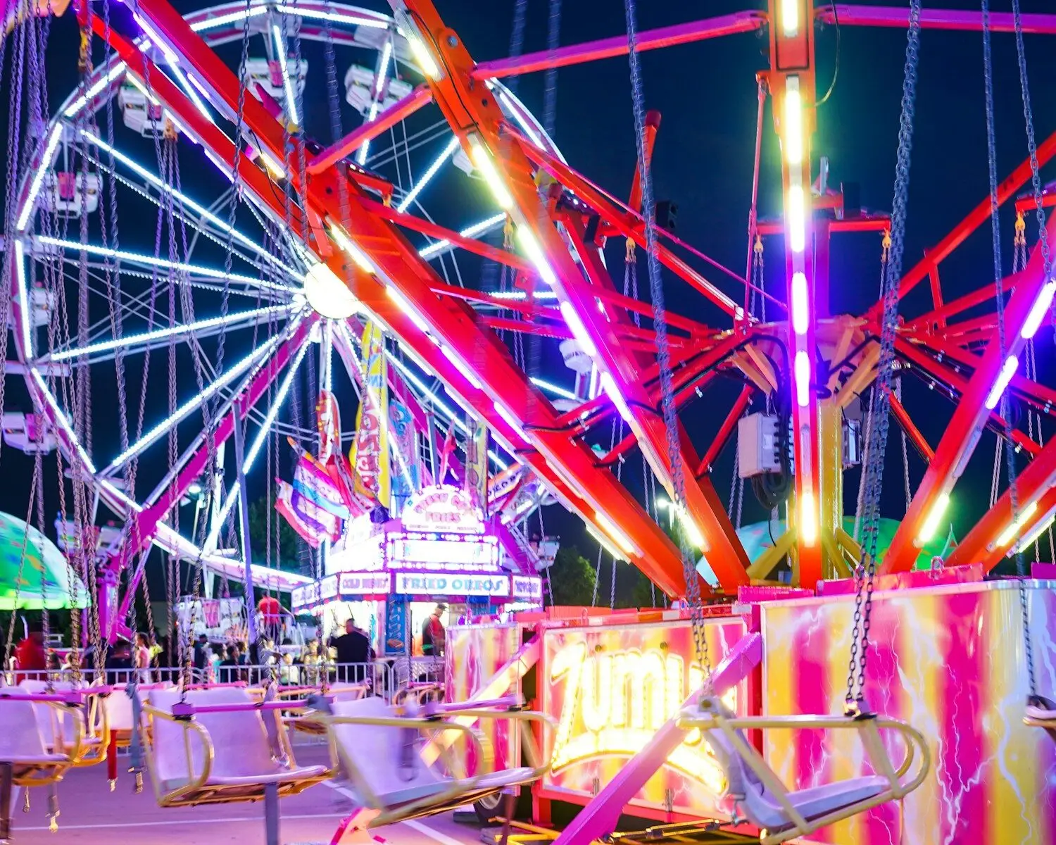 people sitting on chair near ferris wheel during night time