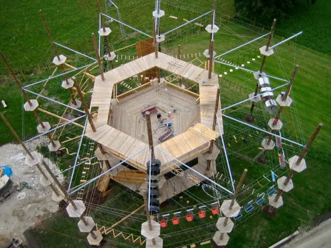 Close-up of a durable geometric climbing tower made of treated timber and sturdy steel ropes.