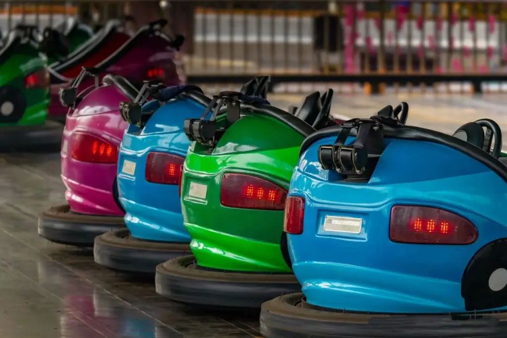 Colorful bumper cars colliding on arena floor with sparks