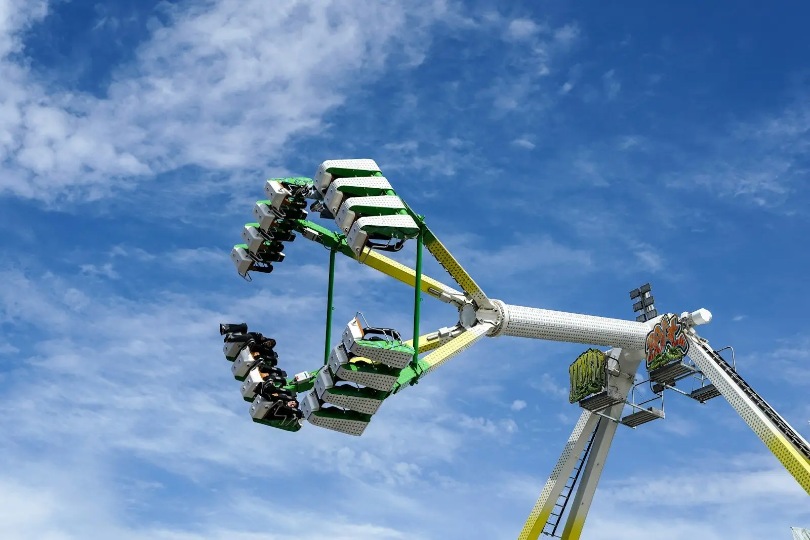 Giant carnival ride with swinging seats against a blue sky.