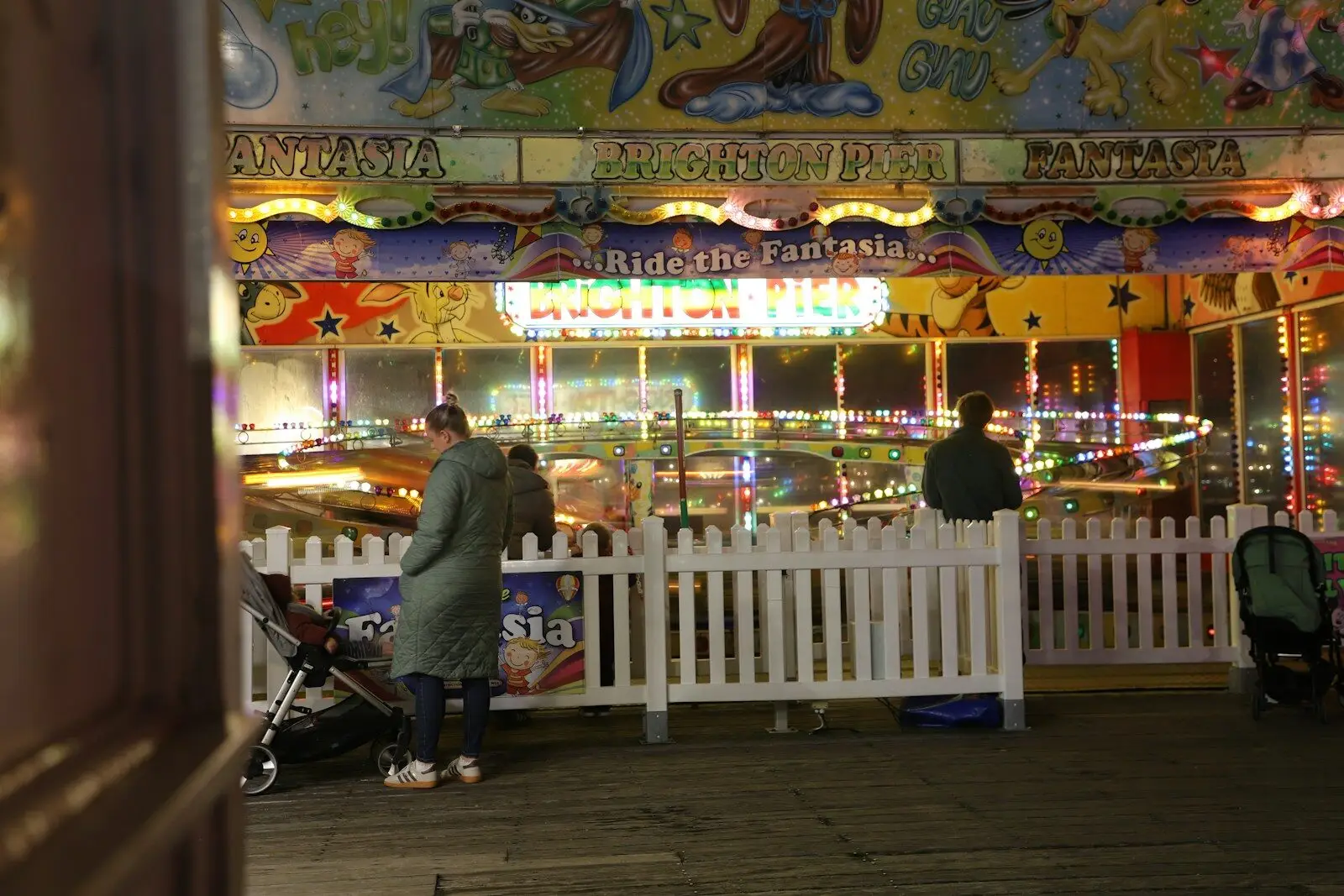 People at a brightly lit amusement park ride