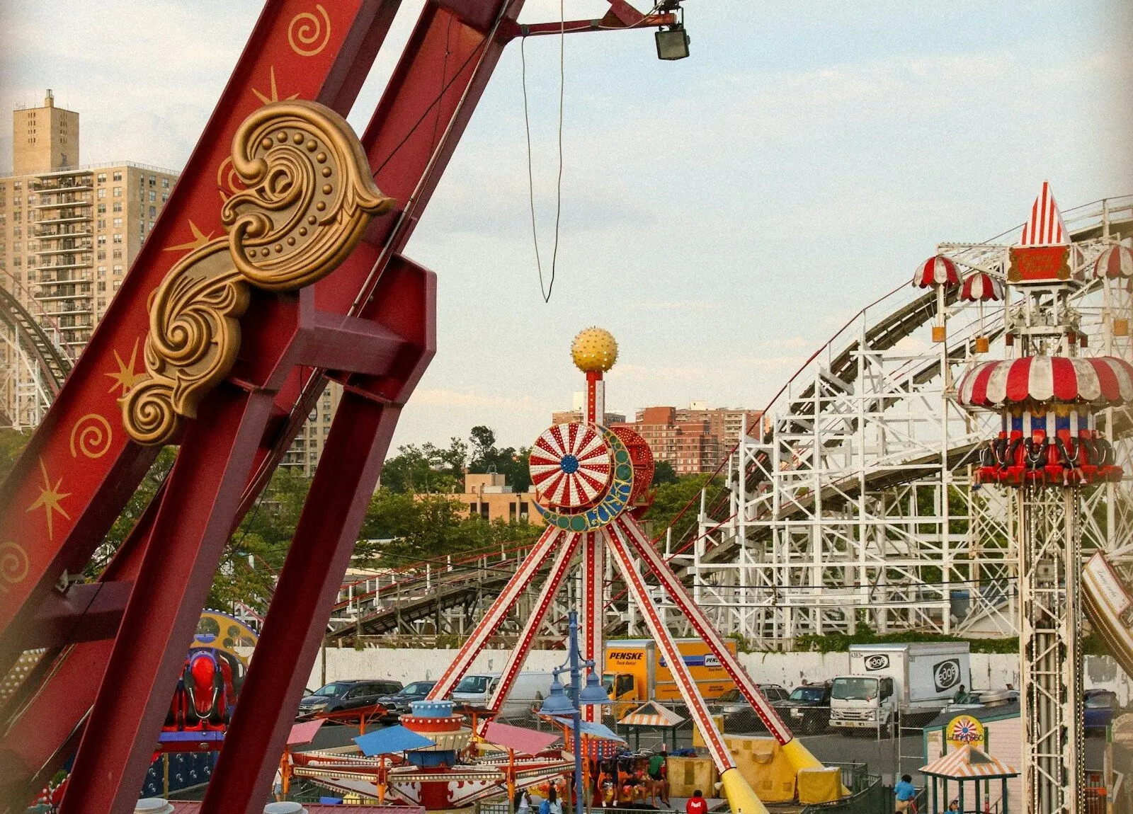 Amusement park rides with roller coaster in background