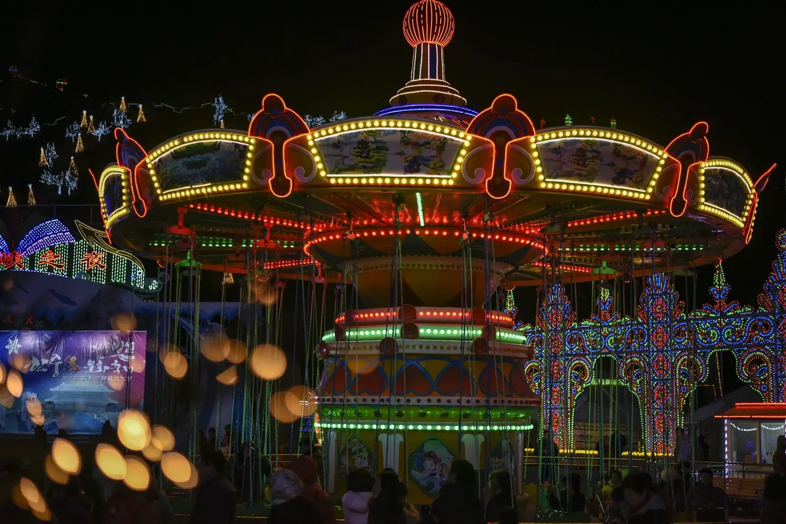 Brightly lit carnival swing ride at night