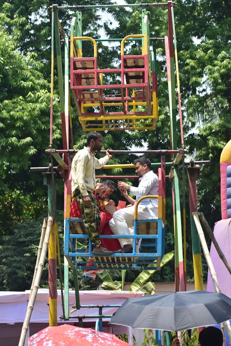 People riding a colorful ferris wheel at an outdoor fair
