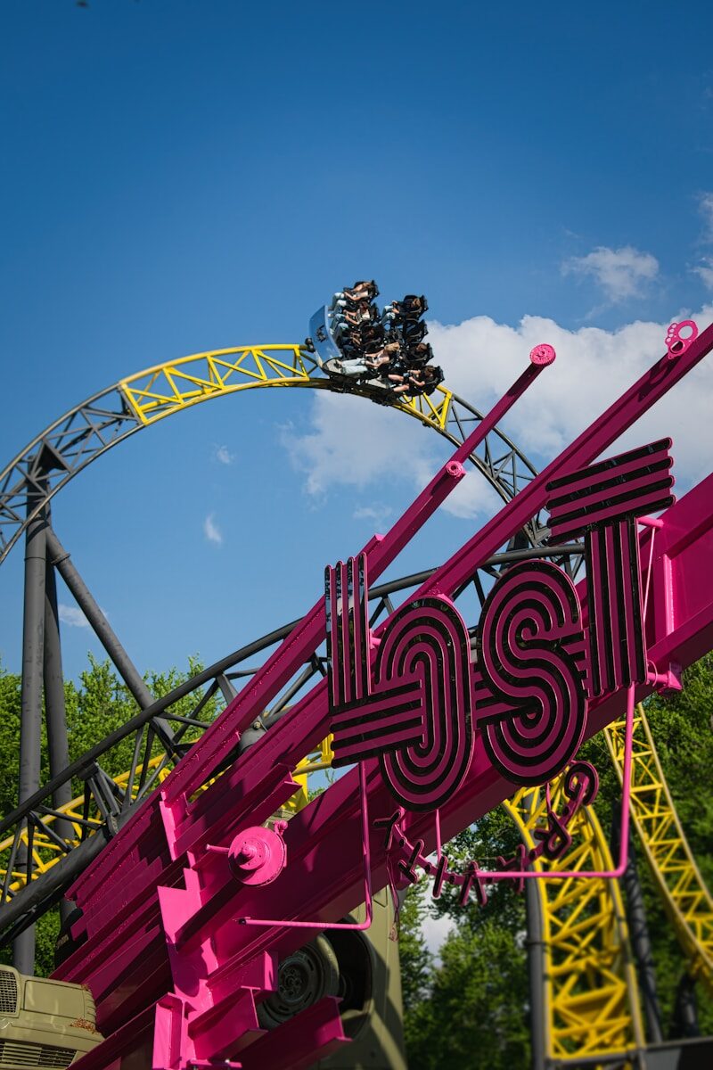 Roller coaster loop with riders and a pink 'lost' sign