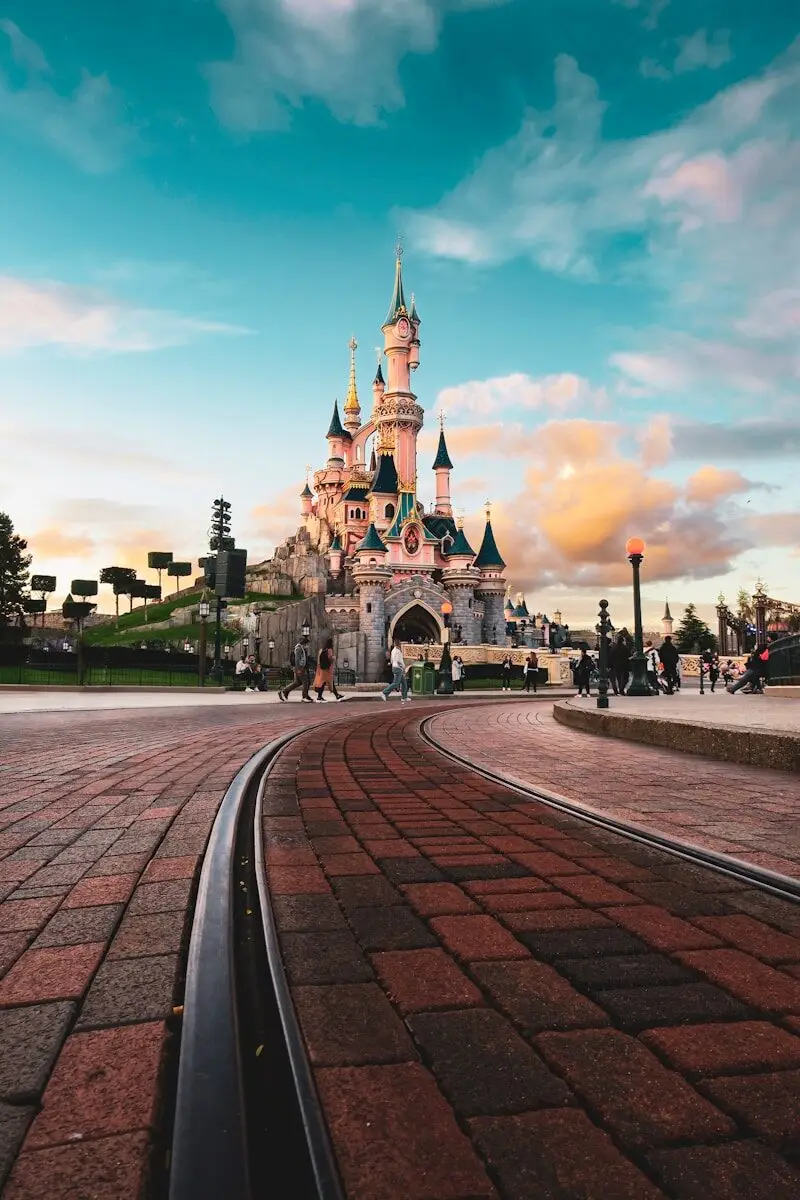 Sleeping Beauty Castle at Disneyland Paris with people walking on a brick path