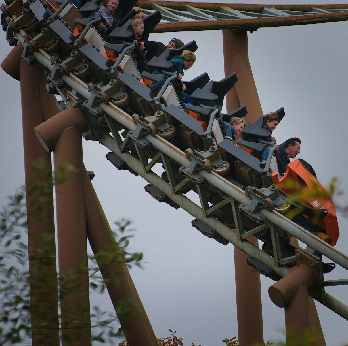 People riding a roller coaster down a track
