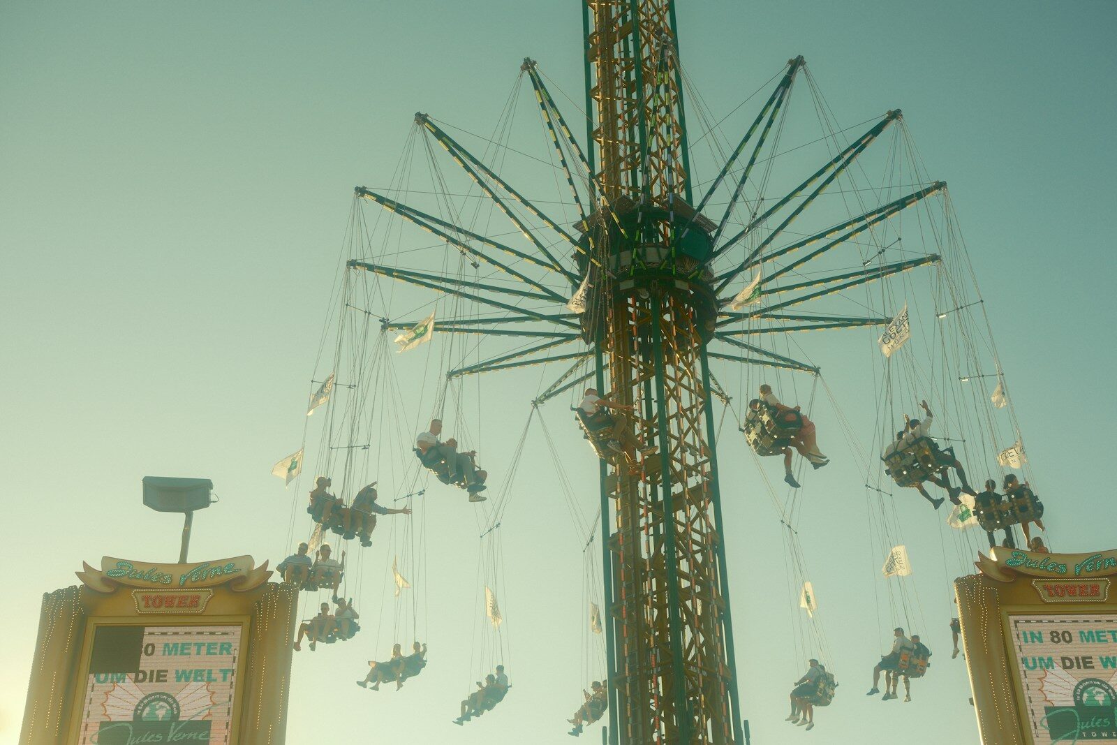 People ride a tall swing ride at a carnival