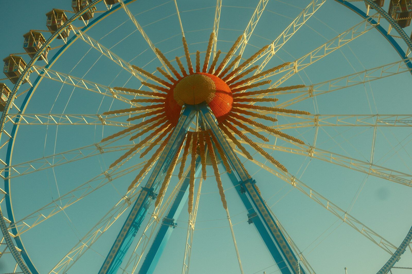 Close-up of a ferris wheel against a clear blue sky