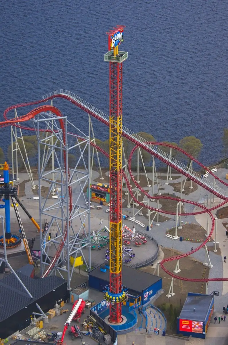 Amusement park with a tall drop tower and roller coasters.