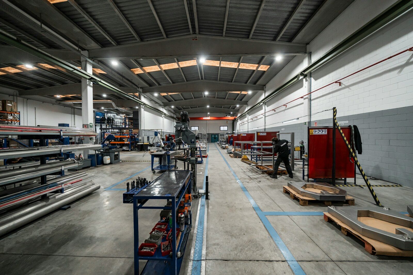 Inside a large factory, equipment and workers are present