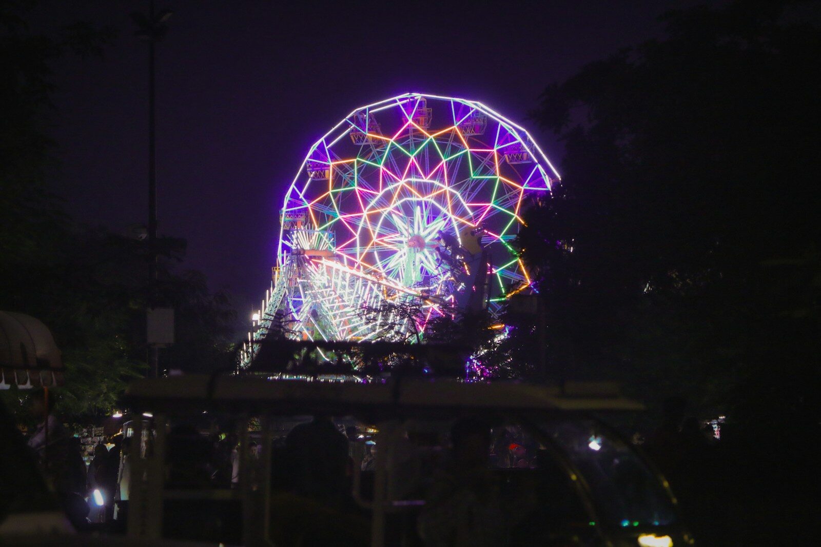 A colorful ferris wheel illuminated at night