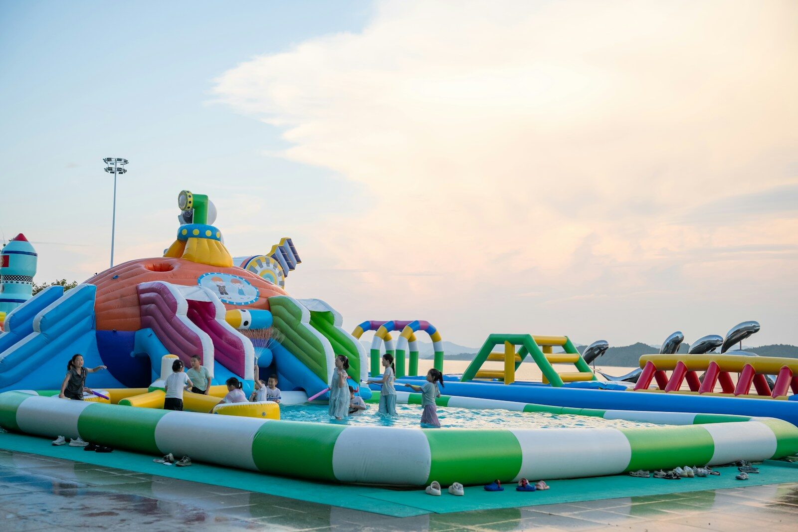 People enjoying a colorful inflatable water park