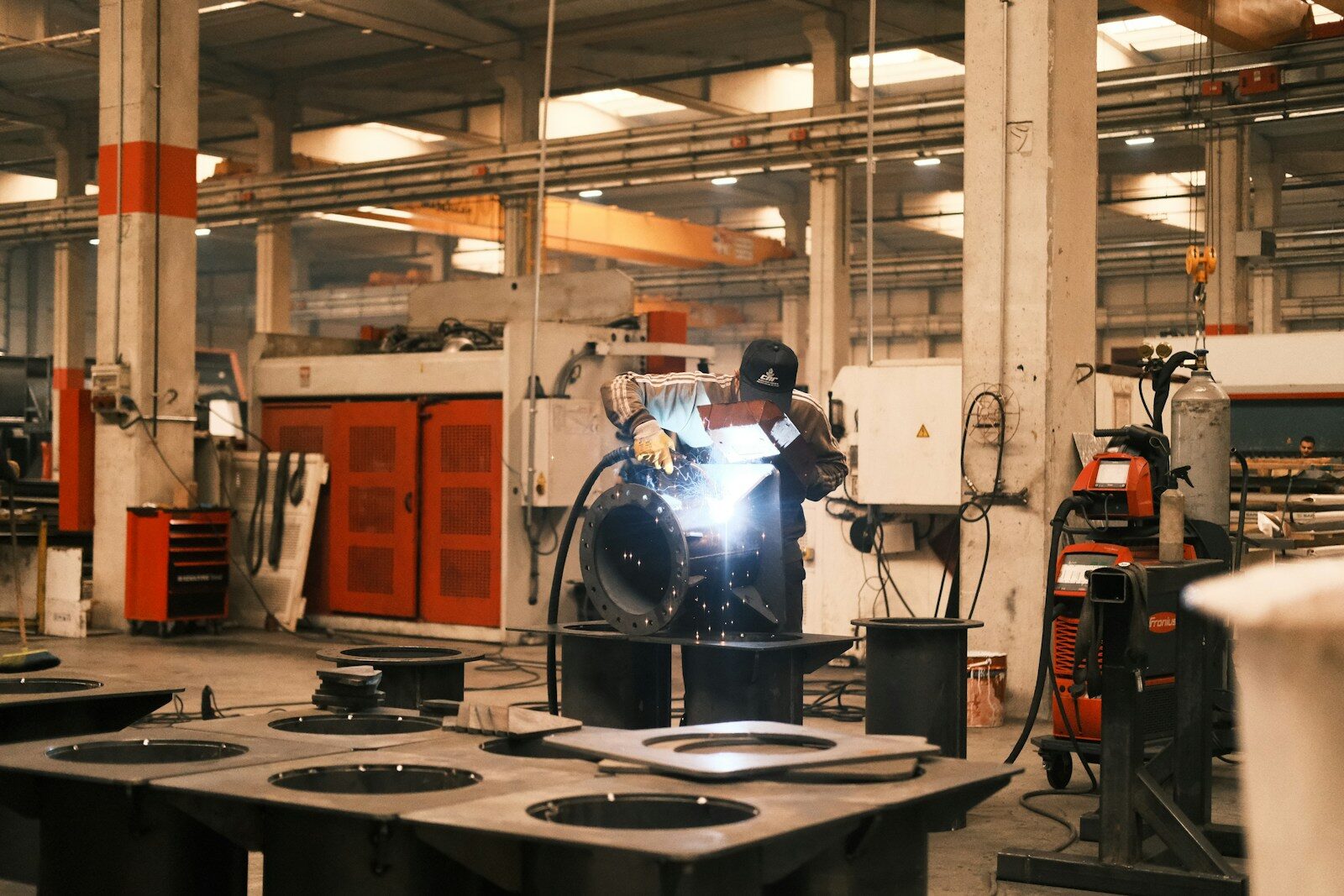 A man welding a piece of metal in a factory