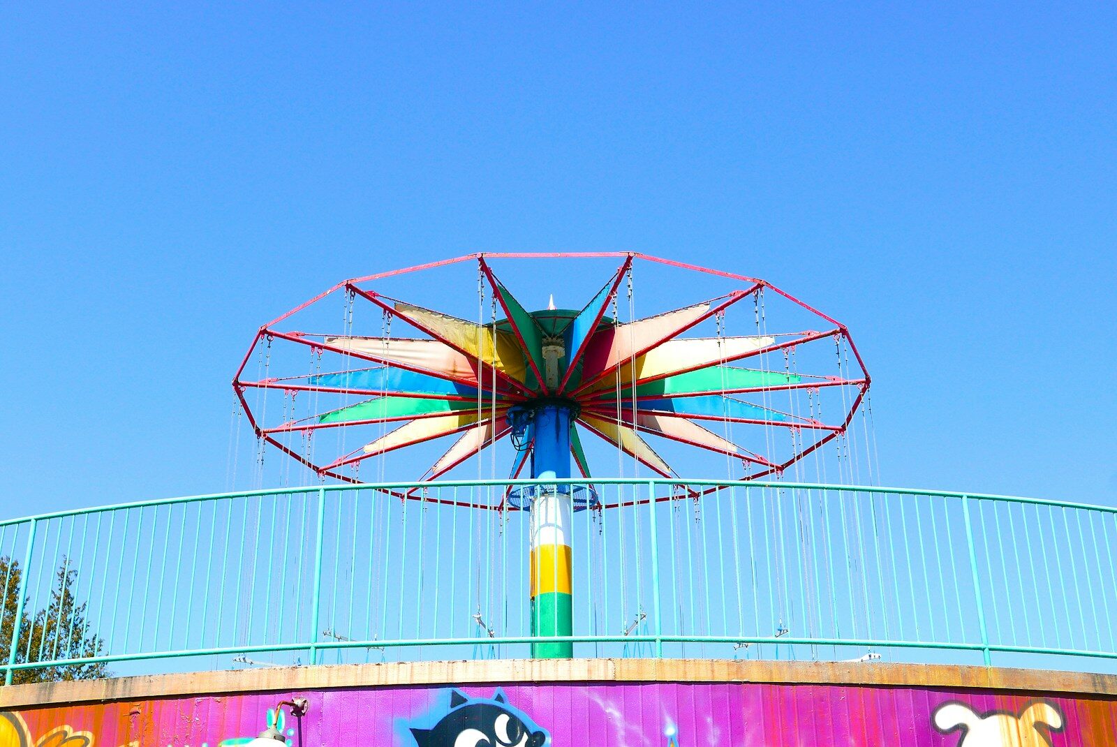 a ferris wheel in front of a colorful wall