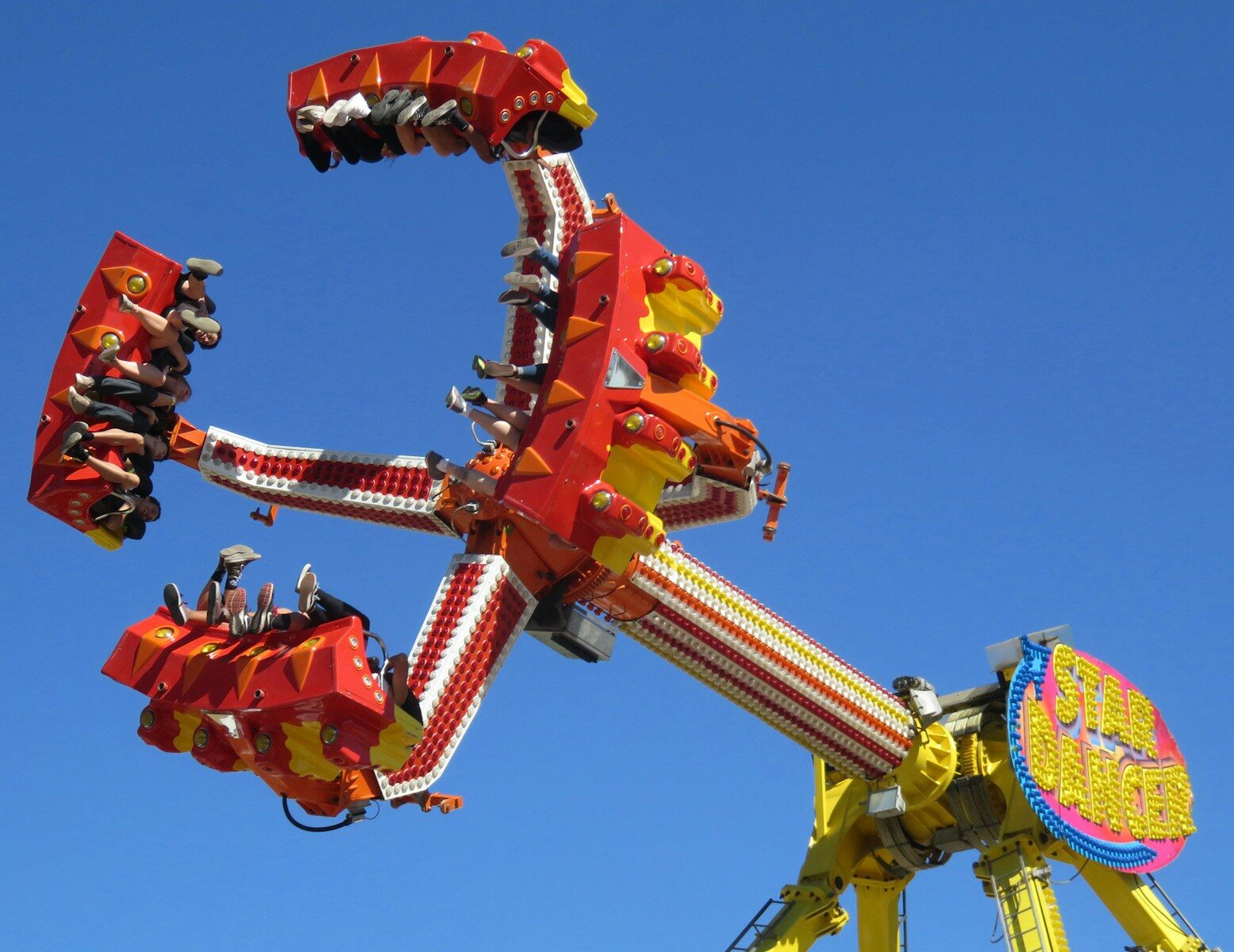 people riding orange and yellow roller coaster during daytime