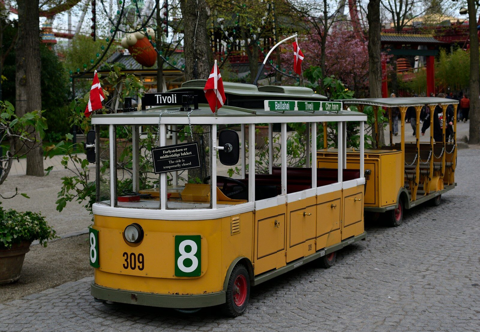 A yellow trolley train with danish flags