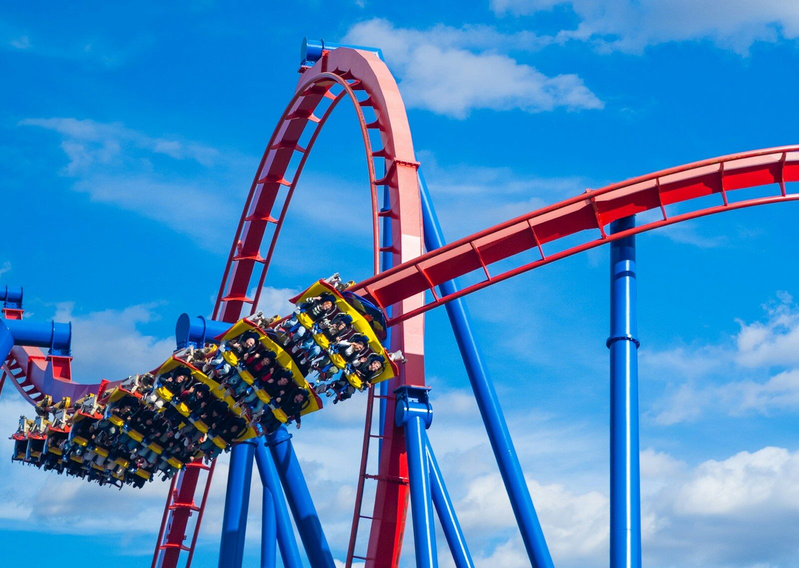 Roller coaster with riders on a sunny day