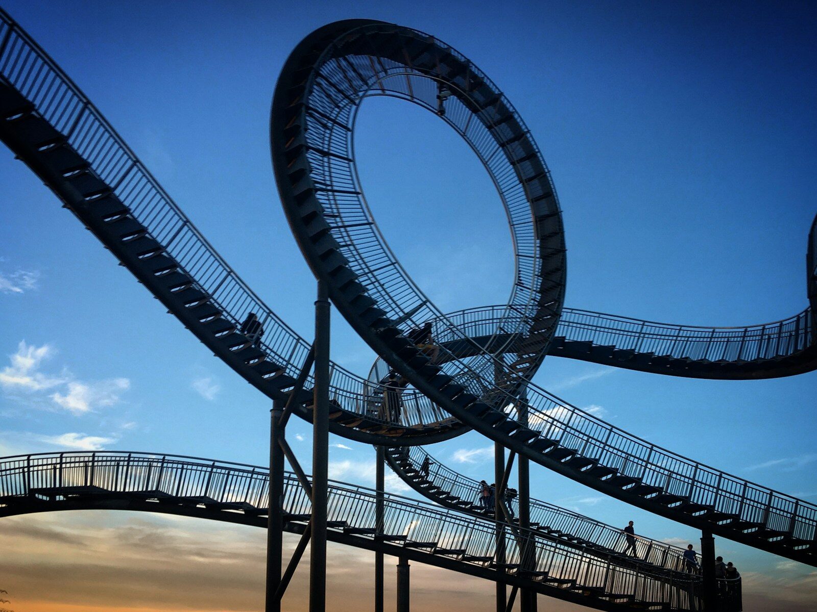 a roller coaster going down a hill at sunset