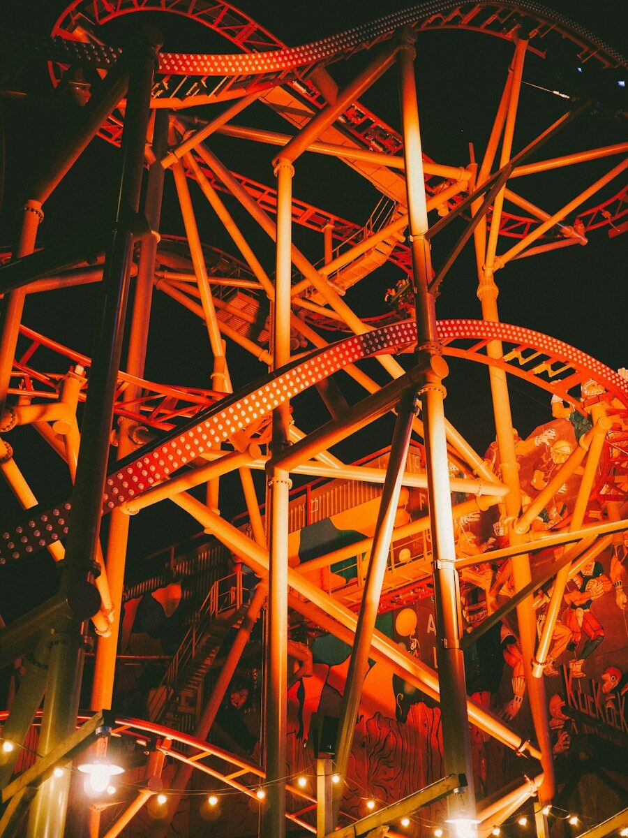 Roller coaster illuminated with orange lights at night