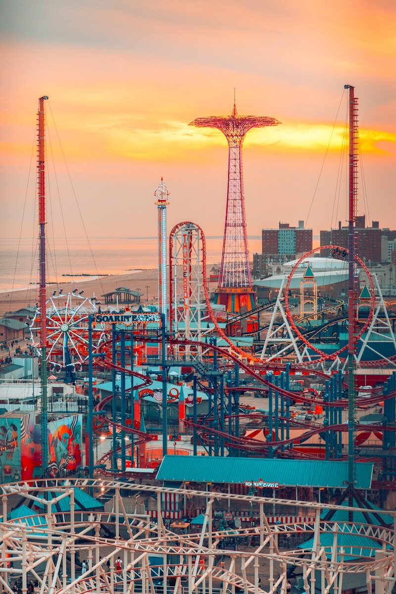 Amusement park rides against a sunset sky