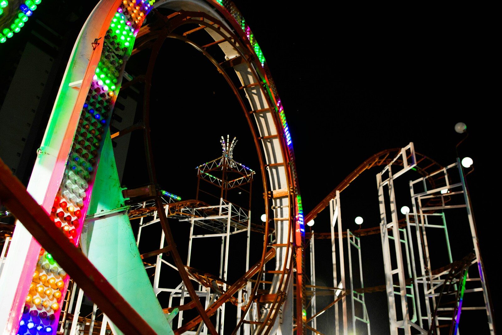 Brightly lit roller coaster at night