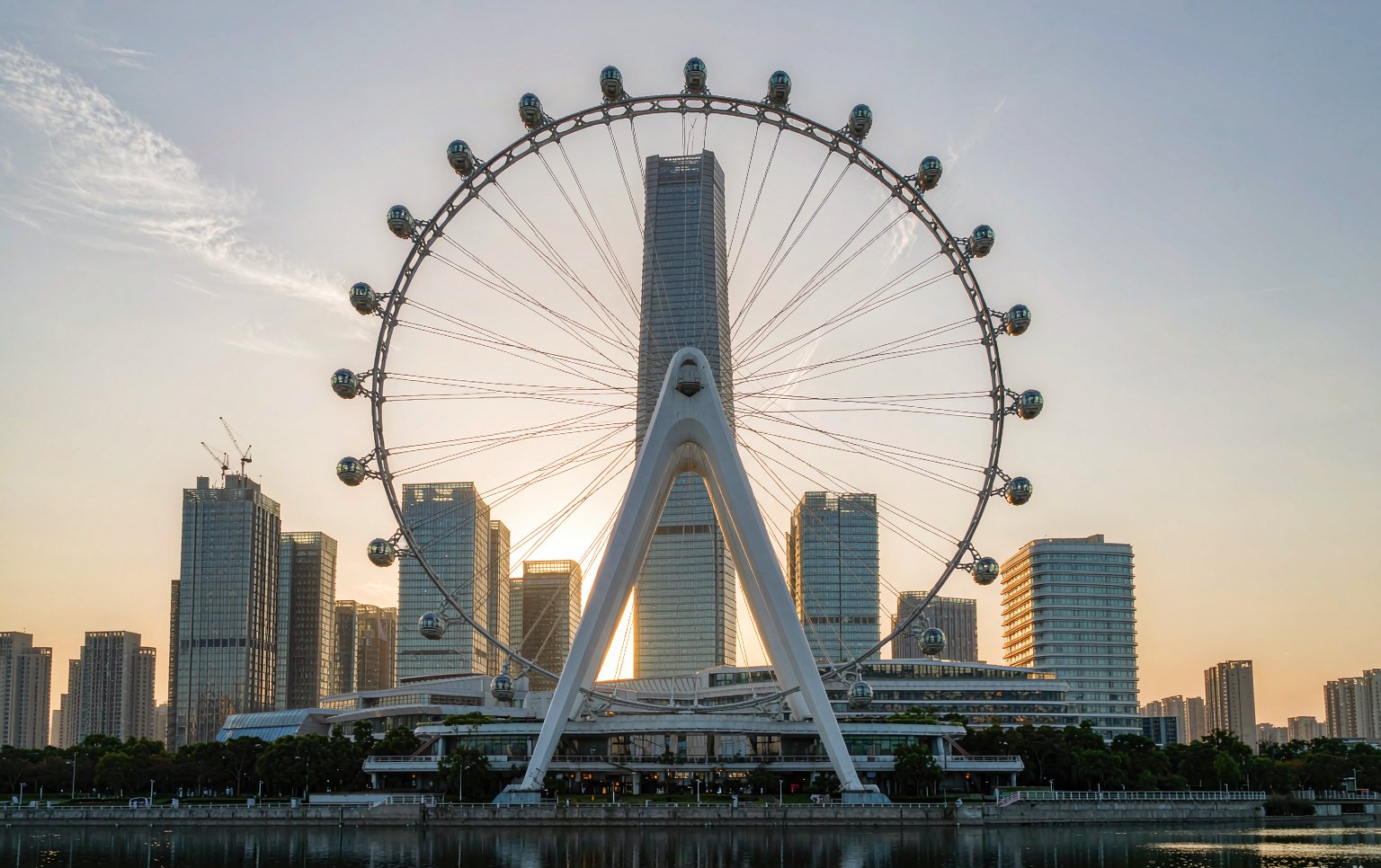 Illuminated 58 m ferris wheel for sale at dusk with enclosed gondolas above a waterfront promenade