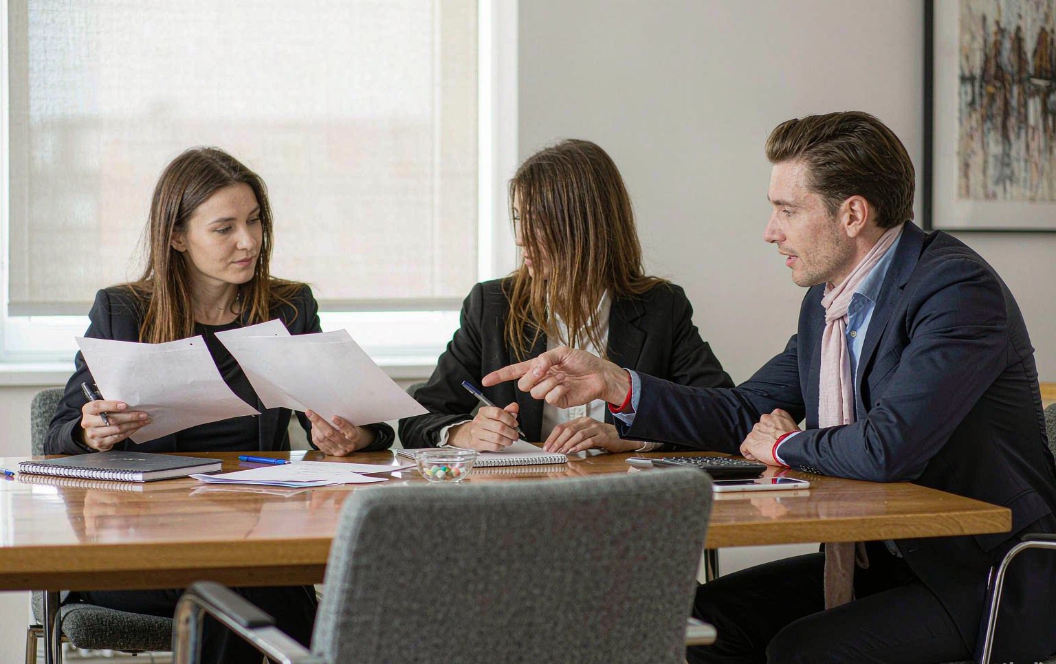 Procurement team reviewing an amusement park rides price quotation beside ride layout drawings
