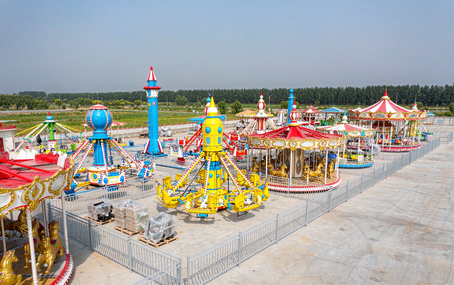 Row of new amusement rides for sale staged at a manufacturer's factory before shipping