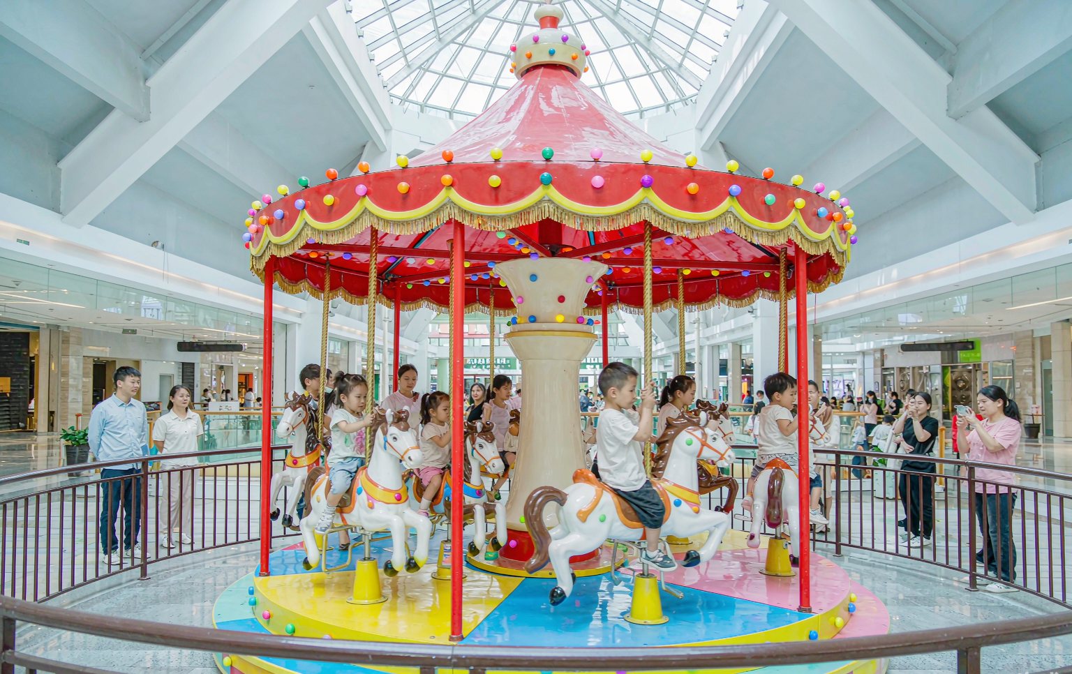 Children riding a mini train from a range of kiddie rides for sale at an outdoor family park
