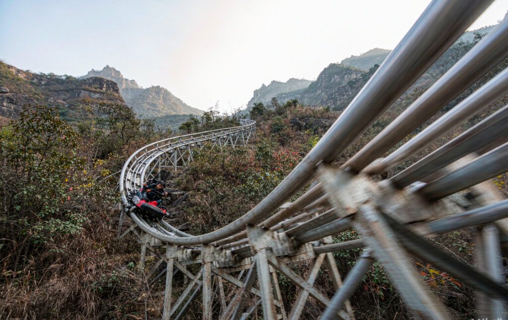 high speed mountain coaster sled taking a steep banked corner with motion blur