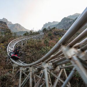 high speed mountain coaster sled taking a steep banked corner with motion blur