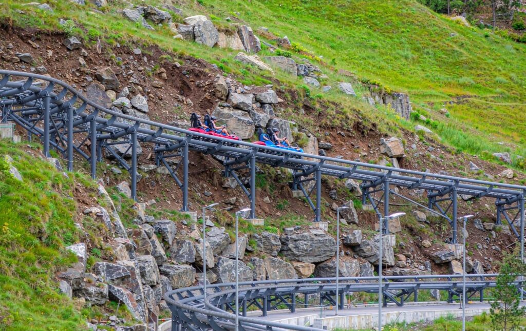 twin-track racing mountain coaster with two riders racing side by side on parallel tracks