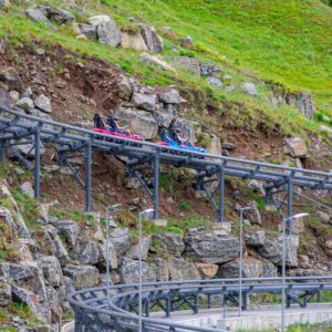 twin-track racing mountain coaster with two riders racing side by side on parallel tracks